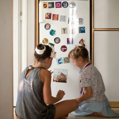 Children showing off their brain game achievement badges at home